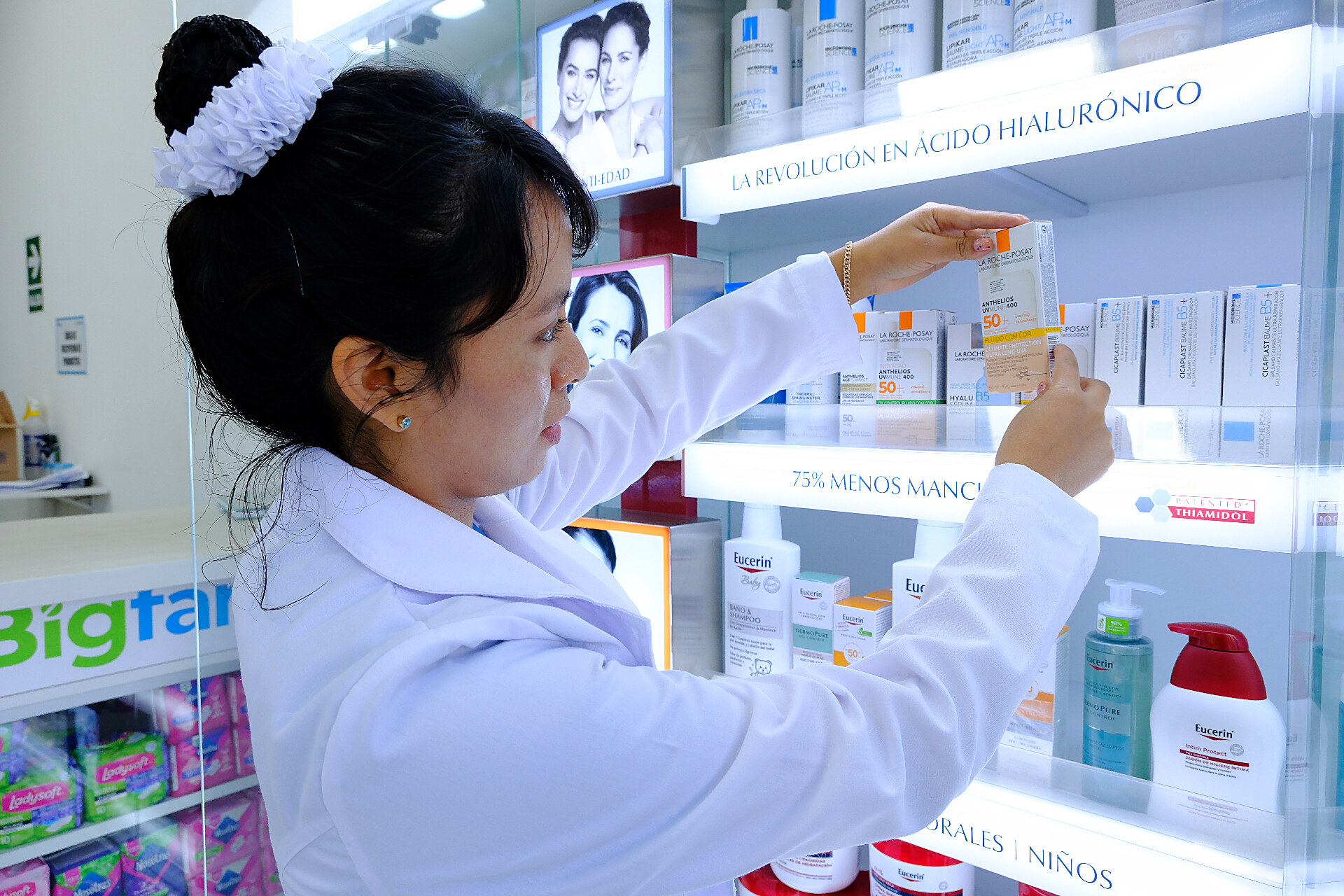 Farmacéutica de BigFarma organizando productos en estantería